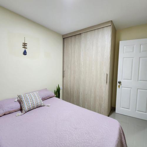 a bedroom with a purple bed and a door at Habitación privada in Filandia