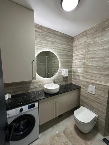 a bathroom with a sink and a toilet and a mirror at Azurno Pristaniste 3 in Njivice
