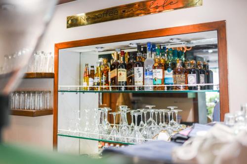 a shelf full of alcohol bottles and glasses at The Sunder Palace-Jaipur City Centre Hotel in Jaipur