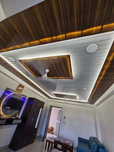 a living room with a coffered ceiling and a television at Walk to Temples in Chhatikara