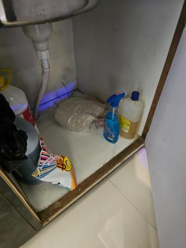 a bathroom with a sink and a shelf with cleaning products at Walk to Temples in Chhatikara