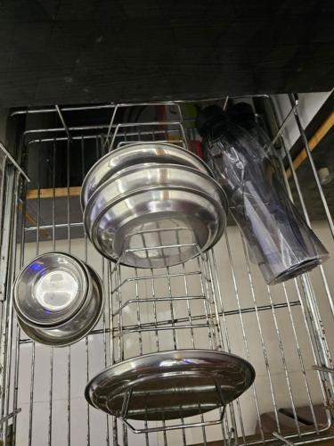 three plates and pans on a shelf in a dishwasher at Walk to Temples in Chhatikara