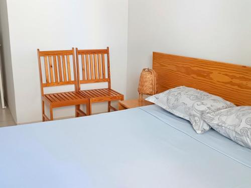a bedroom with a bed and a chair at Mindelo Cozy T2 Downtown in Mindelo