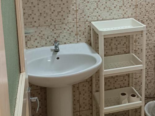 a bathroom with a white sink and a shower at Mindelo Cozy T2 Downtown in Mindelo