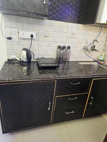 a kitchen counter with a laptop sitting on top of it at Walk to Temples in Chhatikara
