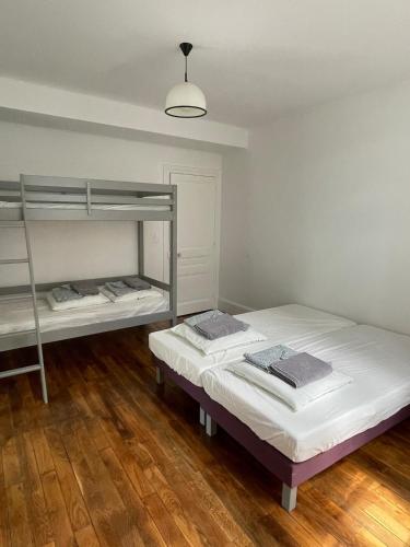 two bunk beds in a room with wooden floors at Gite du canal Artemare Grand Colombier in Artemare