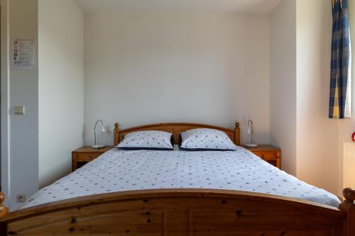 a bedroom with a wooden bed with two pillows at Villa De Ruiter in Waasmunster
