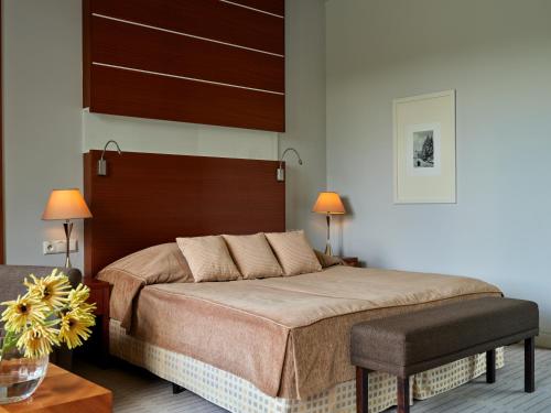 a bedroom with a large bed and two lamps at Hotel SPA Dr Irena Eris Krynica Zdrój in Krynica Zdrój