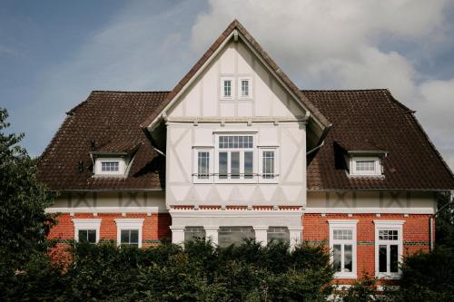 a white house with a brown roof at Pärchen Auszeit am Rande der Heide Tokajer Zimmer in Schwienau