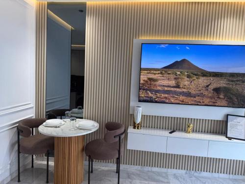 a room with a table and a large tv on a wall at Joli Studio with Seaview 16 in Casablanca