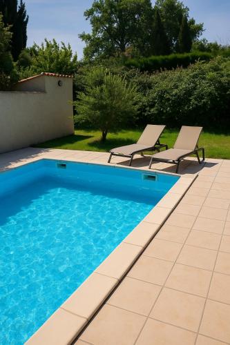 une piscine avec deux chaises longues à côté dans l'établissement Maison 8 pers piscine & BBQ a 5 min Chorégies, à Orange