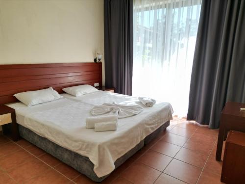 a bedroom with a bed with two towels on it at LEMAS SUITE HOTEL in Side