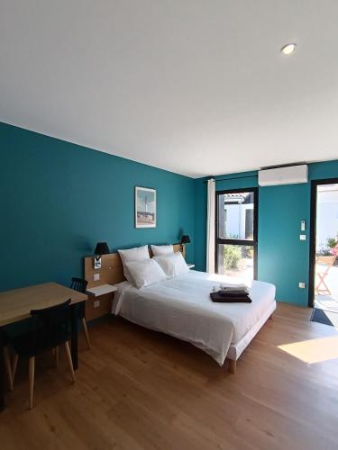 une chambre avec un lit, un bureau et une table dans l'établissement Le Logis de Raphabel, à Saint-Palais-sur-Mer