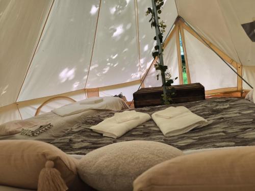 1 cama en una tienda con 2 almohadas en Tente Sancy, en Chambon-sur-Lac