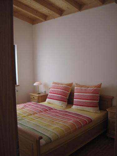 a bedroom with a bed with two striped pillows at Ferienhof auf dem Berg in Gossersweiler-Stein