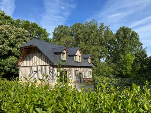 a wooden barn with a black roof at Le Refuge du Tournapile - La Halte in Saint-Léger-Dubosq