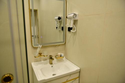 a bathroom with a sink and a mirror at QUT Hotel in Almaty