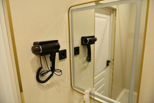a mirror and a hair dryer on a wall at QUT Hotel in Almaty