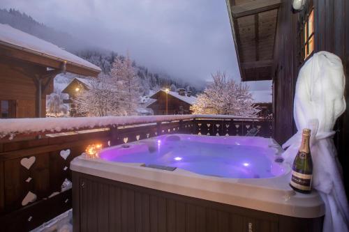 - un bain à remous sur une terrasse avec une bouteille de champagne dans l'établissement Simply Morzine - Chalet Coeur de Morzine, à Morzine