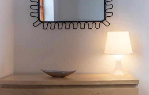 a table with a lamp and a mirror on a wall at Pipeland Farm Steading - No 4 in St. Andrews