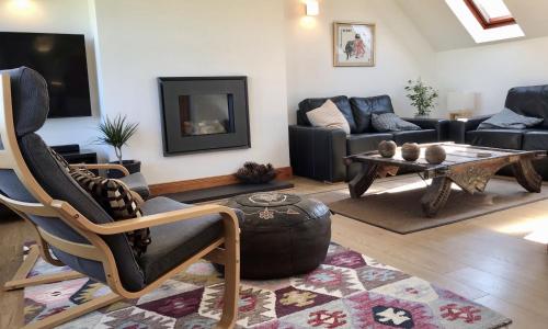 a living room with a couch and a table at Pipeland Farm Steading - No 4 in St. Andrews