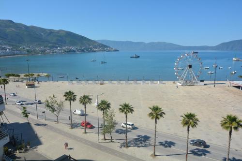 a large beach with palm trees and a ferris wheel at Alba Suites in Vlorë