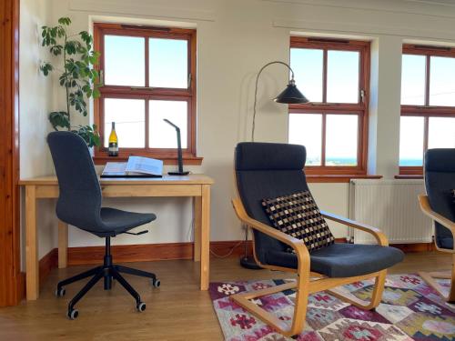 a room with a desk and two chairs and a table at Pipeland Farm Steading - No 4 in St. Andrews
