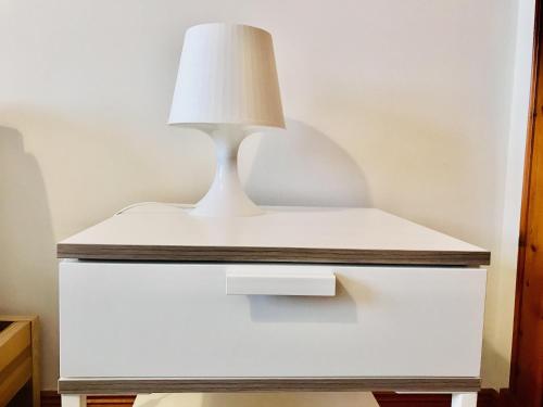 a white lamp on top of a white dresser at Pipeland Farm Steading - No 4 in St. Andrews