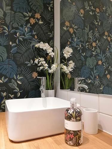 a bathroom with a white sink and a floral wallpaper at Autour d'une Toile in Rouvenac