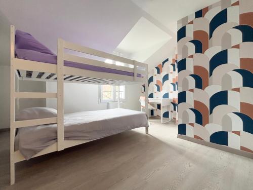 une chambre avec des lits superposés avec un mur géométrique dans l'établissement 10min de Disney Duplex 2ch avec Parking & Balcon, à Bailly-Romainvilliers