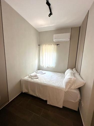 a small bedroom with a bed with a window at Azurno Pristaniste 1 in Njivice
