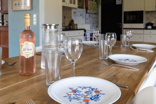 a wooden table with glasses and a bottle of wine at Villa De Ruiter in Waasmunster