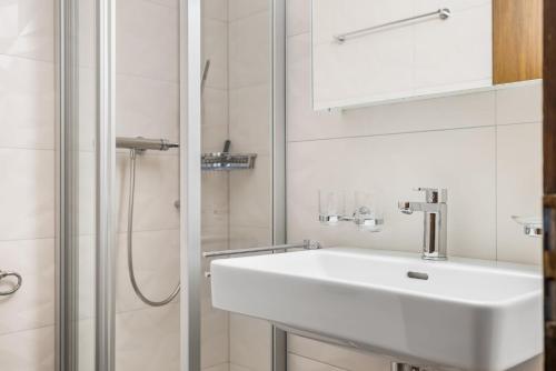 un bagno bianco con lavandino e doccia di Arnica 2 - 2 pers - piscine a Nendaz