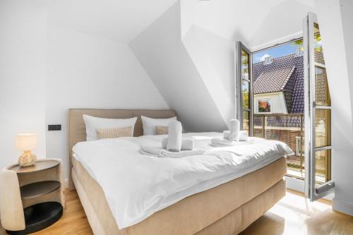 une chambre avec un lit et une grande fenêtre dans l'établissement Sky & Sand, à Westerland