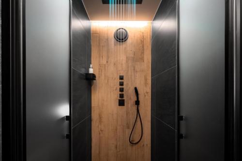 a bathroom with a shower with a wooden door at Wellness apartmány BARTH Holiday in Dolní Morava