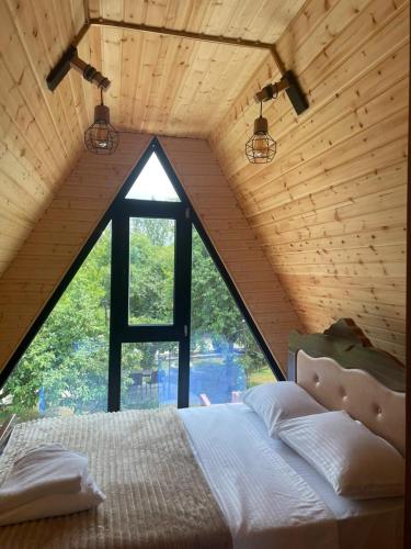 a bed in a room with a large window at Typebi in K'obulet'i