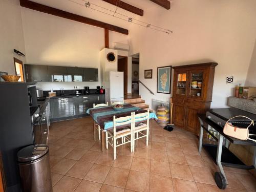 a kitchen and dining room with a table and chairs at Maison Authentique Corse Vue Mer Panoramique et Nature Sauvage in Zonza