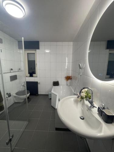 a bathroom with a sink and a tub and a toilet at Metropolitan am Schloßpark in Paderborn