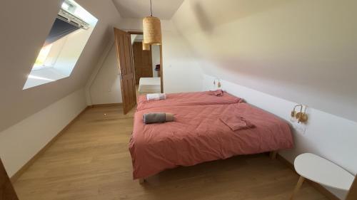 a bedroom with a bed with a red blanket at La ferme Le Clos de la Becque in Muncq-Nieurlet