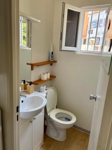 une salle de bain avec toilettes, lavabo et fenêtre dans l'établissement Studio du port, au Cap d'Agde