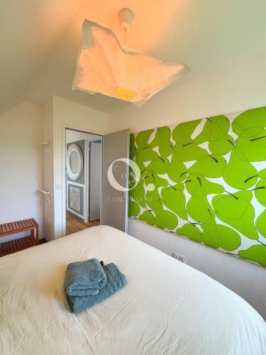 a bedroom with a bed with a green wall at COC - Villa Parenthèse in Tardinghen