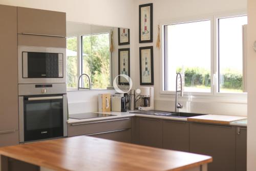 a kitchen with a sink and a microwave at COC - Villa Parenthèse in Tardinghen