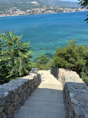 a stone wall with stairs leading to the ocean at Azurno Pristaniste 1 in Njivice