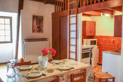 une cuisine avec une table avec un vase de fleurs dessus dans l'établissement Gîte Gîtes de France 2/4 personnes à Molines, à Ispagnac