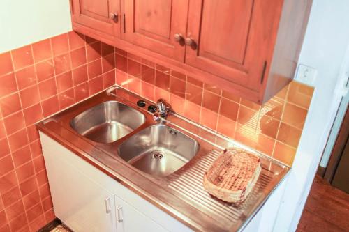 - un évier de cuisine avec un panier à côté dans l'établissement Gîte Gîtes de France 2/4 personnes à Molines, à Ispagnac