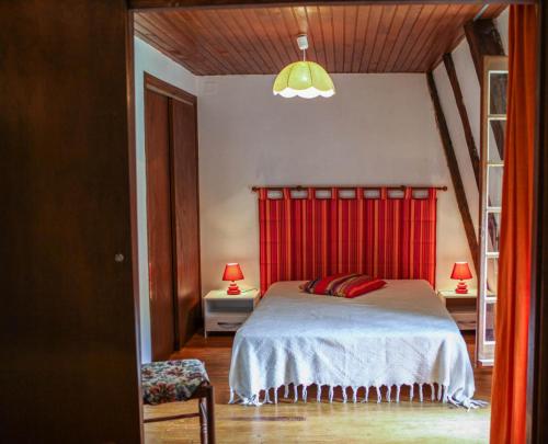 une chambre avec un lit avec une tête de lit rouge dans l'établissement Gîte Gîtes de France 2/4 personnes à Molines, à Ispagnac