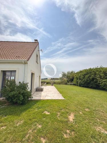a house with a grass yard next to a building at COC - Villa Parenthèse in Tardinghen