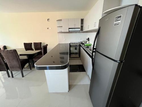 a kitchen with a black refrigerator and a table at Tu Espacio Exclusivo Privacidad y Comodidad in Tacna