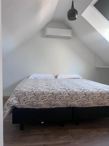 une chambre avec un lit dans une pièce blanche dans l'établissement Aux Tours du Gîte, à Leval