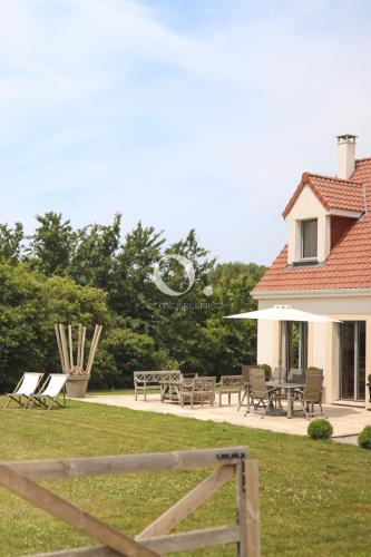 a house with chairs and tables in a yard at COC - Villa Parenthèse in Tardinghen